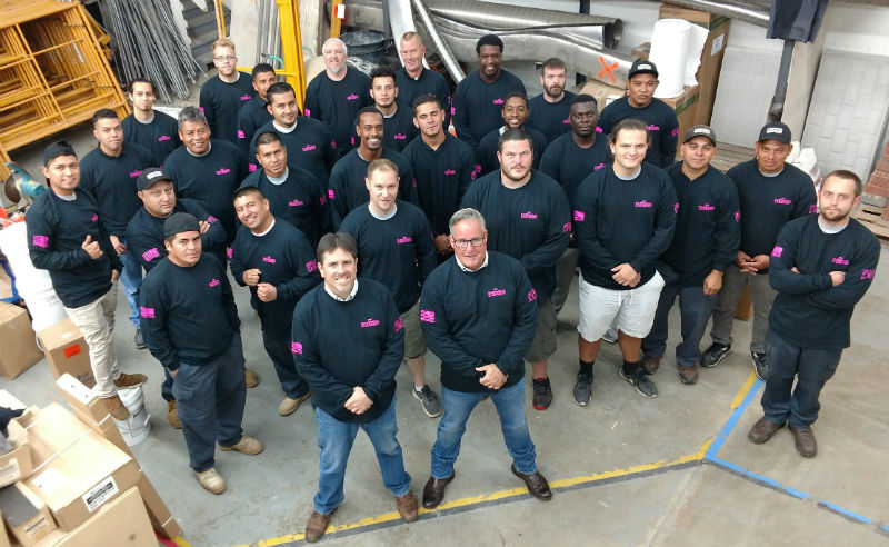 Aerial view of Winstons Chimney Team Wearing Sweep Out Cancer Shirts Inside Warehouse