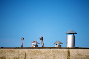 line of old rusty chimneys with caps