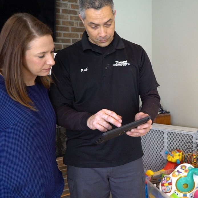 chimney tech looking over findings with customer