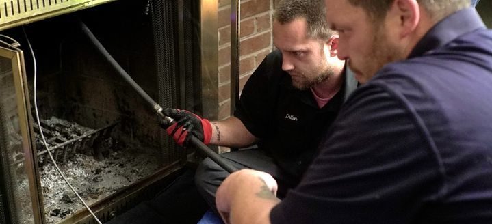 Two chimney technicians performing chimney inspection