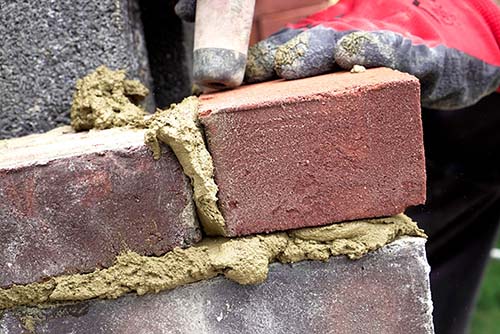 Winstons Chimney Original Photo of Chimney Masonry Restoration Close up of technician hands performing restoration of masonry