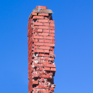a red masonry chimney with missing bricks and deterioration