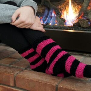 a person wearing cozy socks sitting by a gas fireplace