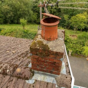 a masonry chimney with a clay top that's damaged and discolored