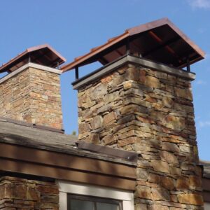 two stone chimneys, each with a large chimney cap