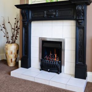 a white and black gas fireplace with a big vase and plant next to it