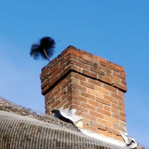 a masonry chimney with a chimney sweep brush coming out of the top