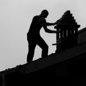 a black silhouette of a chimney sweep by a chimney 